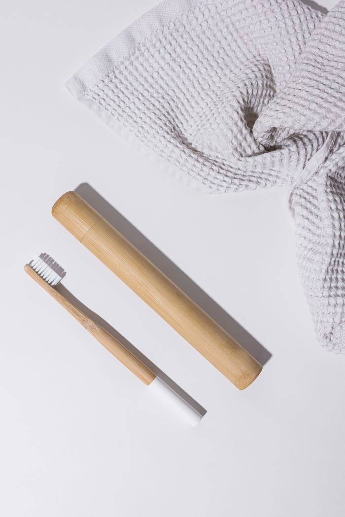 about-01 Minimalist bamboo toothbrush and face towel in bright flat lay for eco-conscious living.